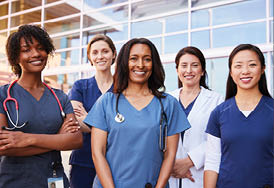 Female healthcare colleagues standing outside hospital